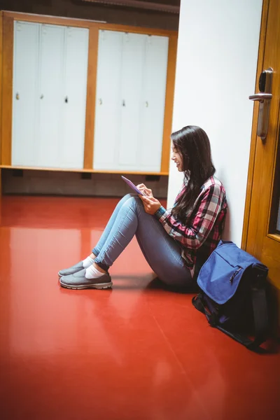 Étudiant souriant assis sur le sol et utilisant une tablette — Photo