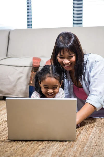 Feliz joven madre usando el ordenador portátil con su hija — Foto de Stock