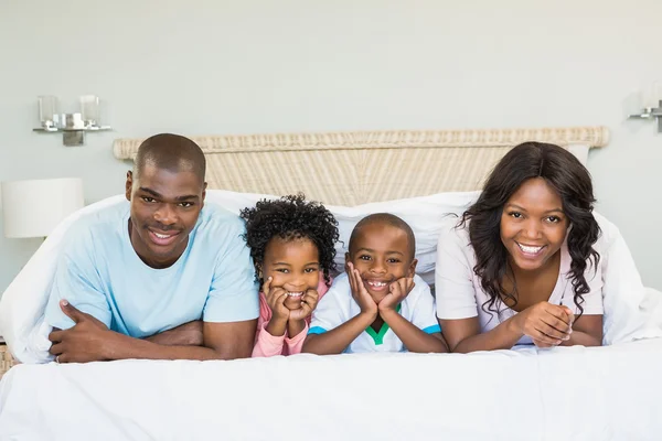 Famille heureuse couchée sur le lit — Photo
