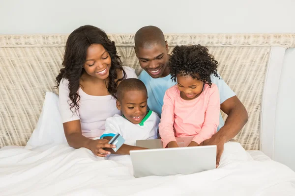 Lycklig familj handla online med laptop — Stockfoto