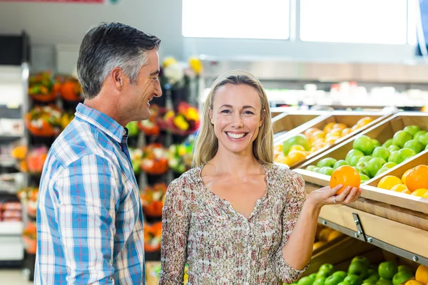 Glückliches lächelndes Paar pflückt Orange — Stockfoto