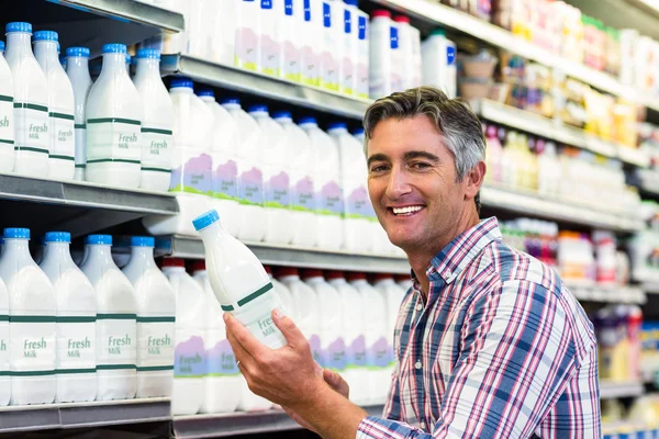 Pria tersenyum memegang botol susu — Stok Foto