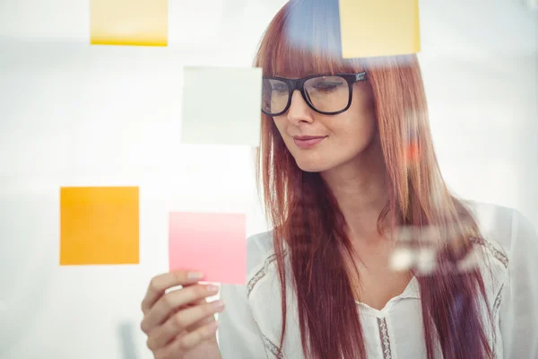 Aantrekkelijke hipster vrouw kijken naar kleverige nota 's — Stockfoto