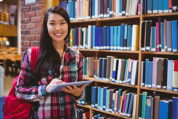 Lächelnder Student in Bibliothek mit Tablet — Stockfoto