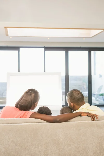 Över axeln syn på casual familjen tittar på tv — Stockfoto