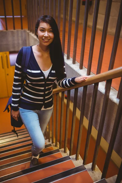 Smiling student walking up steps — Stock Photo, Image