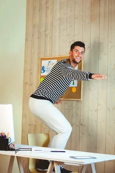 Man pretending to surf on his chair — Stock Photo, Image