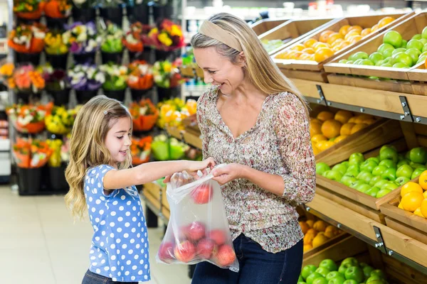 Mother and daughter picking out apple — Stock Photo, Image