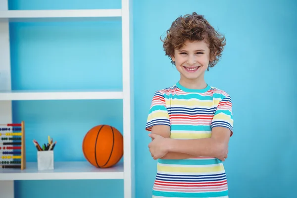 Sorrindo menino de pé ao lado de alguns brinquedos — Fotografia de Stock