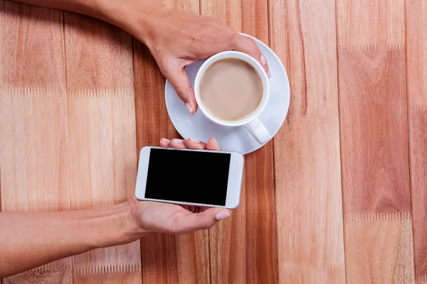 Mãos segurando smartphone e café — Fotografia de Stock