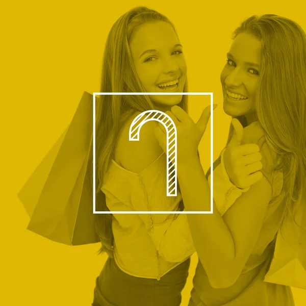 Duas mulheres jovens o polegar com sacos de compras — Fotografia de Stock