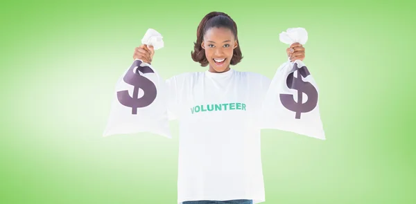 Para çantaları tutan gönüllü kadın gülümsüyor — Stok fotoğraf