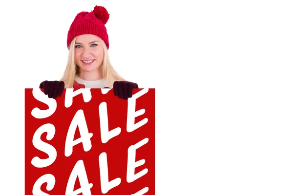 Festive blonde showing a red poster — Stock Photo, Image