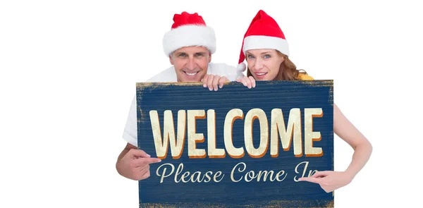 Casal festivo mostrando um cartaz — Fotografia de Stock