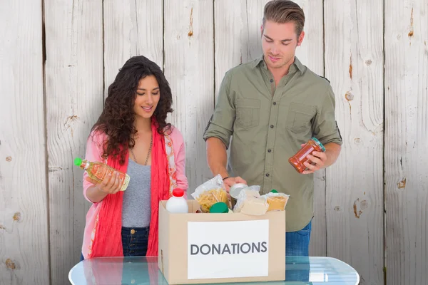 Volunteers taking out food from donations box — Stock Photo, Image