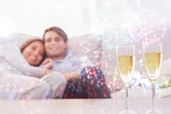 Coppia sdraiata sul divano con champagne — Foto Stock