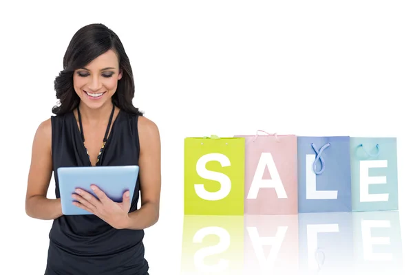 Elegant brown haired model typing on tablet — Stock Photo, Image