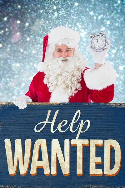 Composite image of santa claus holding alarm clock and sign — Stock Photo, Image