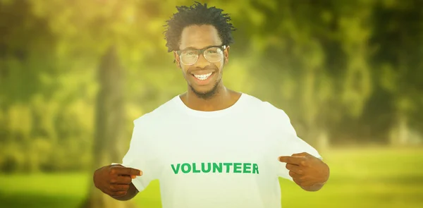 Schöner Mann zeigt auf sein freiwilliges T-Shirt — Stockfoto