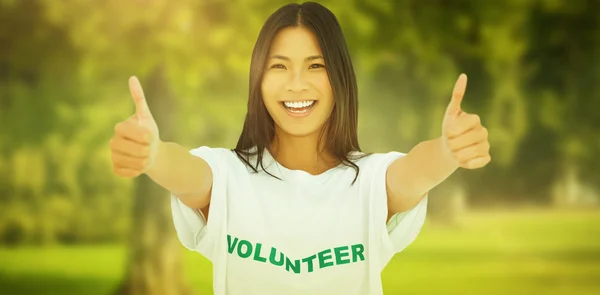 Женщина в волонтерской футболке показывает большие пальцы вверх — стоковое фото