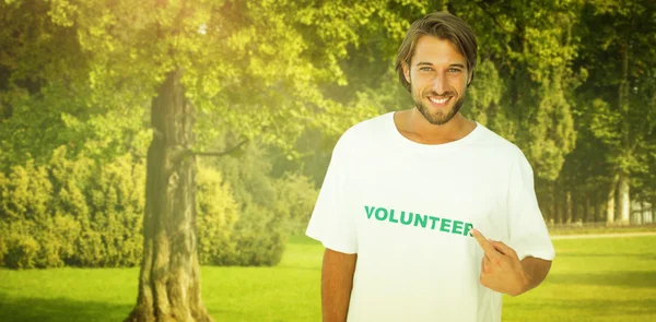 Lächelnder Mann zeigt auf sein freiwilliges T-Shirt — Stockfoto