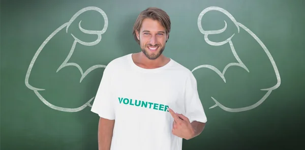 Sonriente hombre señalando a su camiseta voluntaria — Foto de Stock