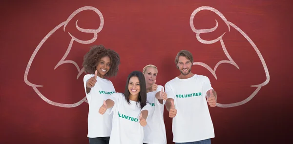 Happy group of volunteers giving thumbs up — Stock Photo, Image