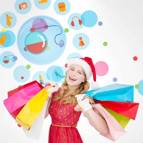 Rubia en santa hat sosteniendo bolsas de compras —  Fotos de Stock