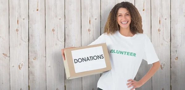 Voluntario sonriente sosteniendo una caja de donaciones — Foto de Stock