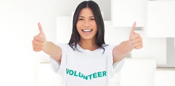 Mujer vistiendo camiseta voluntaria dando pulgares arriba — Foto de Stock