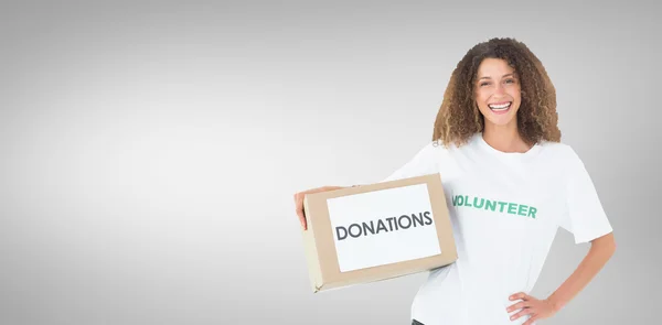 Voluntario sonriente sosteniendo una caja de donaciones — Foto de Stock