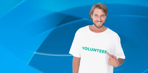 Lächelnder Mann zeigt auf sein freiwilliges T-Shirt — Stockfoto