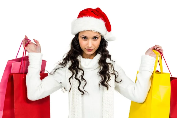 Mulher com chapéu de Natal segurando sacos de compras coloridos — Fotografia de Stock