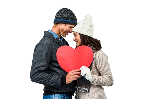 Ζευγάρι στο χειμωνιάτικα ρούχα κρατώντας την καρδιά — Φωτογραφία Αρχείου