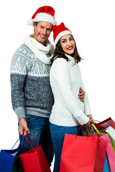 Festliches Paar lächelt und hält Geschenktüten in der Hand — Stockfoto