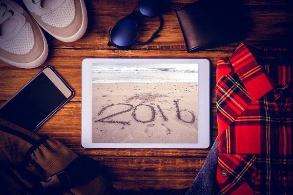 Tablet tegen 2016 op zand op strand — Stockfoto