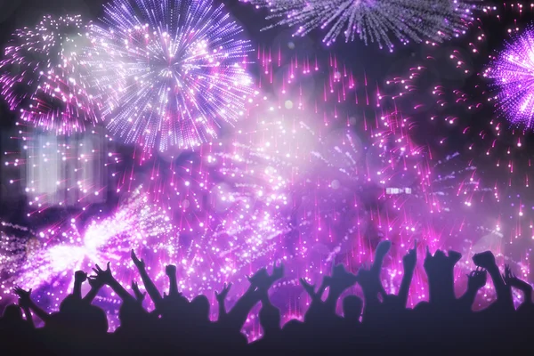 Siluetas celebrando contra fuegos artificiales de colores —  Fotos de Stock