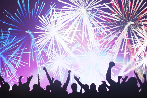 Sziluettek ünneplő, színes tűzijáték ellen — Stock Fotó