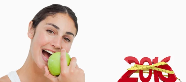 Брюнетка ест зеленое яблоко — стоковое фото