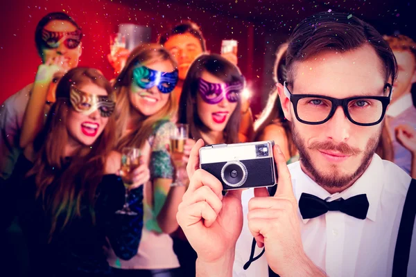 Geeky hipster holding a retro camera — Stock Photo, Image