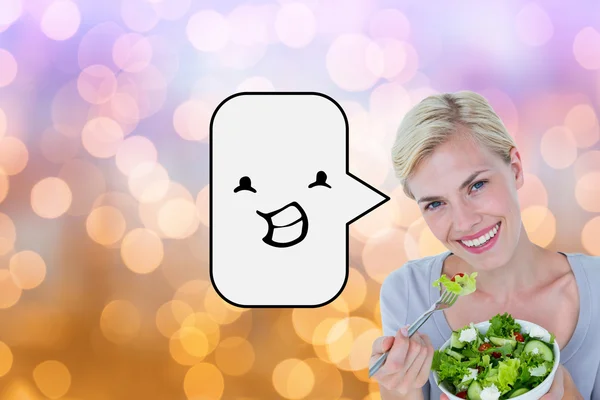 Happy blonde woman holding bowl of salad — Stock Photo, Image