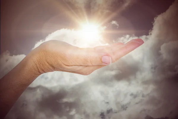 Mano contra el cielo azul con nubes — Foto de Stock