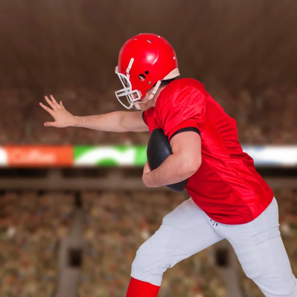 Jogador de futebol americano correndo com a bola — Fotografia de Stock