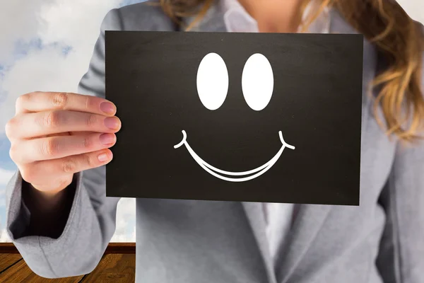 Composite image of businesswoman showing card — Stock Photo, Image