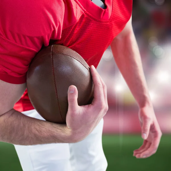 American football speler een bal overneemt in haar hand — Stockfoto