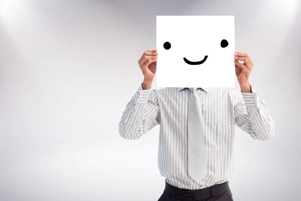 Businessman holding a white card covering his face — Stock Photo, Image