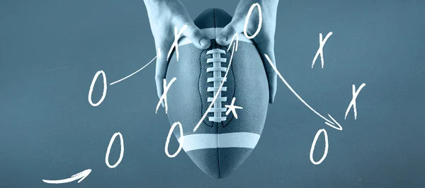 American football player holding up football — Stock Photo, Image