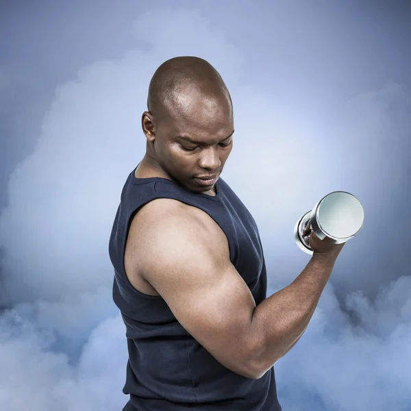 Muscular man exercising with dumbbell — Stock Photo, Image