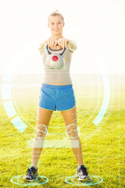 Sorrindo esportivo loira exercício com kettlebell — Fotografia de Stock