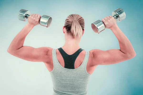 Mulher muscular trabalhando com halteres — Fotografia de Stock